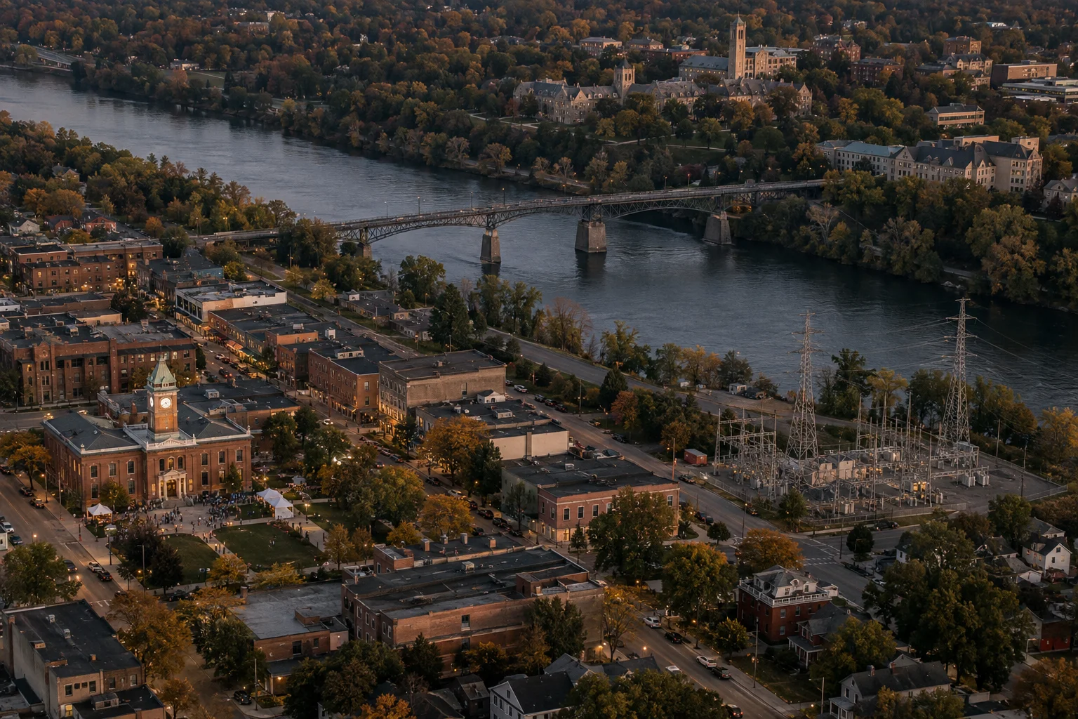 An illustrative river town: a gathering outside the town hall, a steel bridge, an electrical substation, and a campus among the trees.